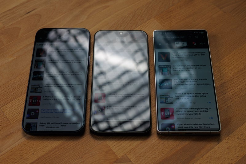 Three phone screens showing reflections while display is very dim..