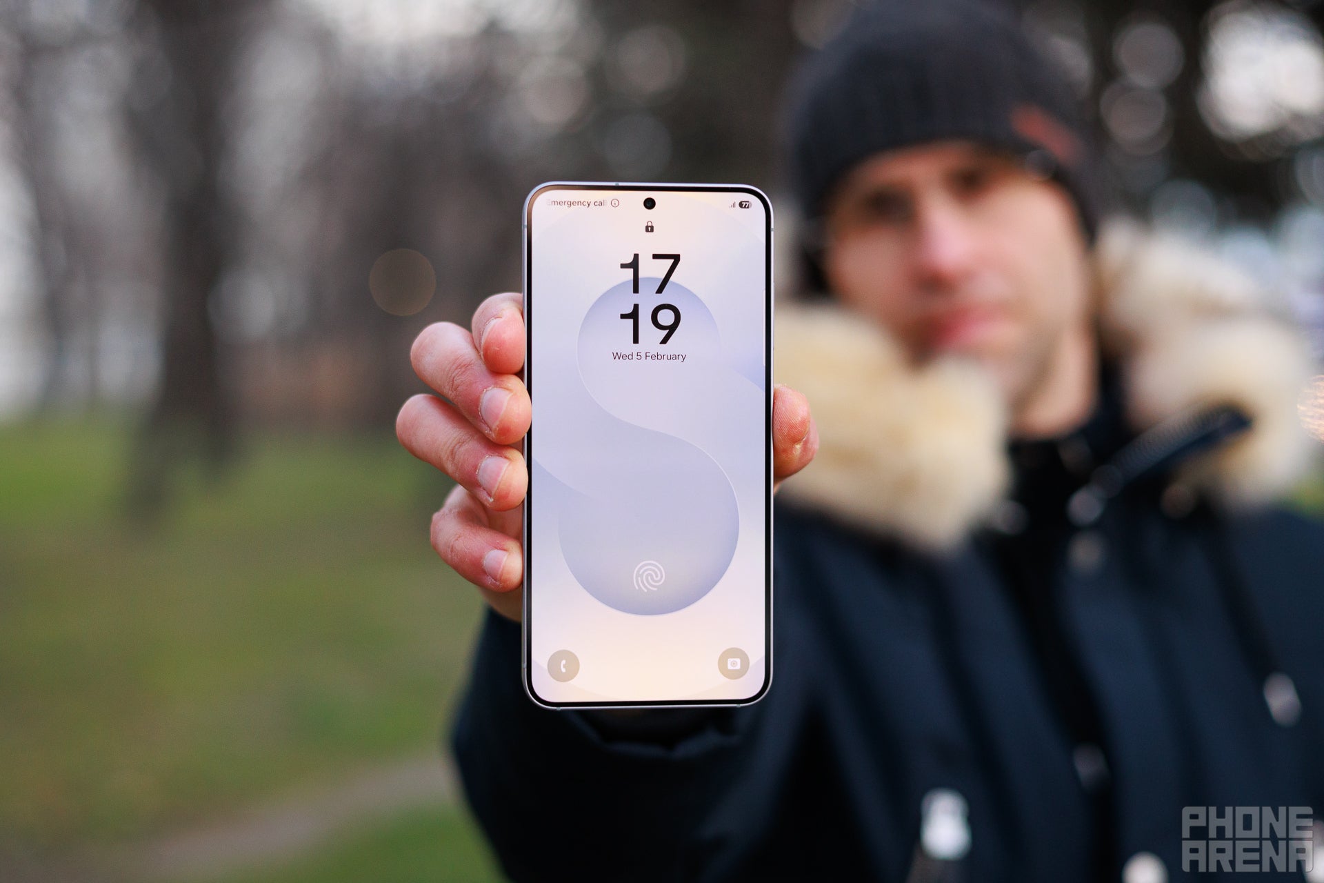 "A man holding an S25 in his hand. | Image by PhoneArena - The Galaxy S26's peak brightness numbers might leave you disappointed