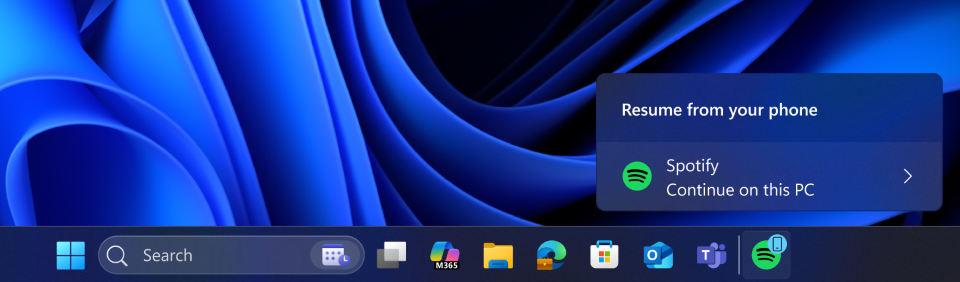 A Windows 11 taskbar showing a notification from the Spotify app, which prompts the user to &amp;#039;Resume from your phone&amp;#039; and &amp;#039;Continue on this PC&amp;#039;.