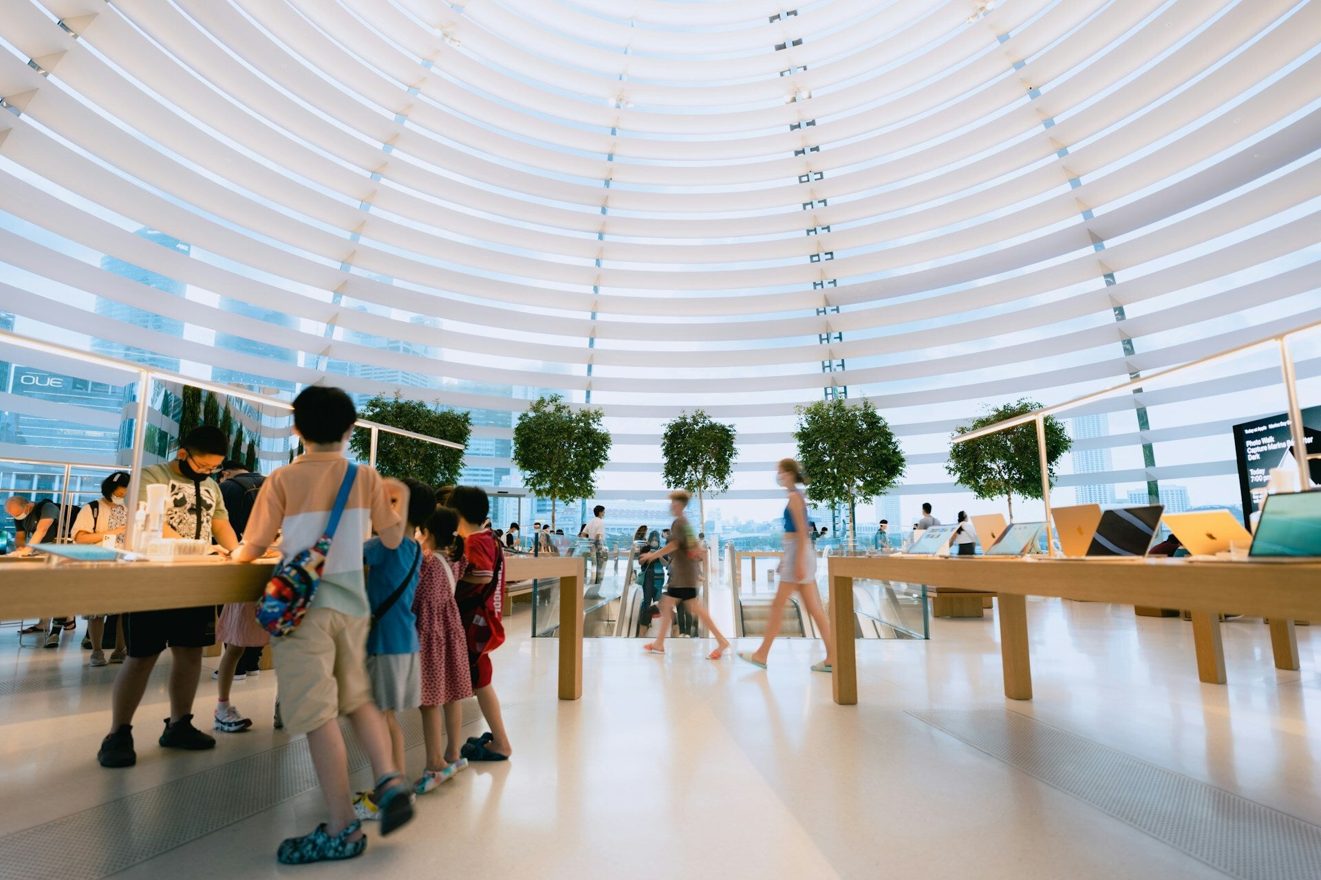 People browsing devices inside a bright, dome-shaped tech store.
