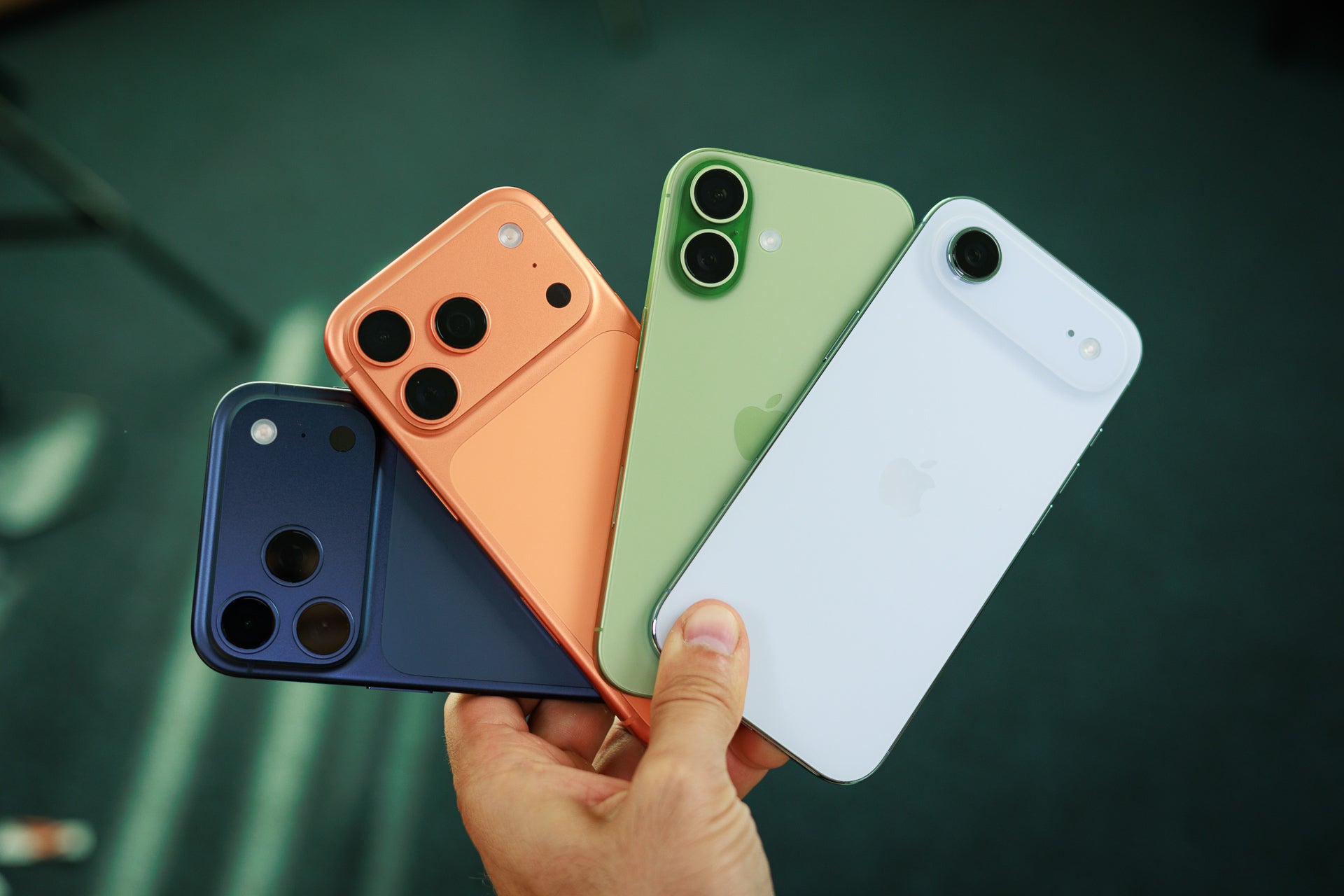 Four iPhones held in hand.