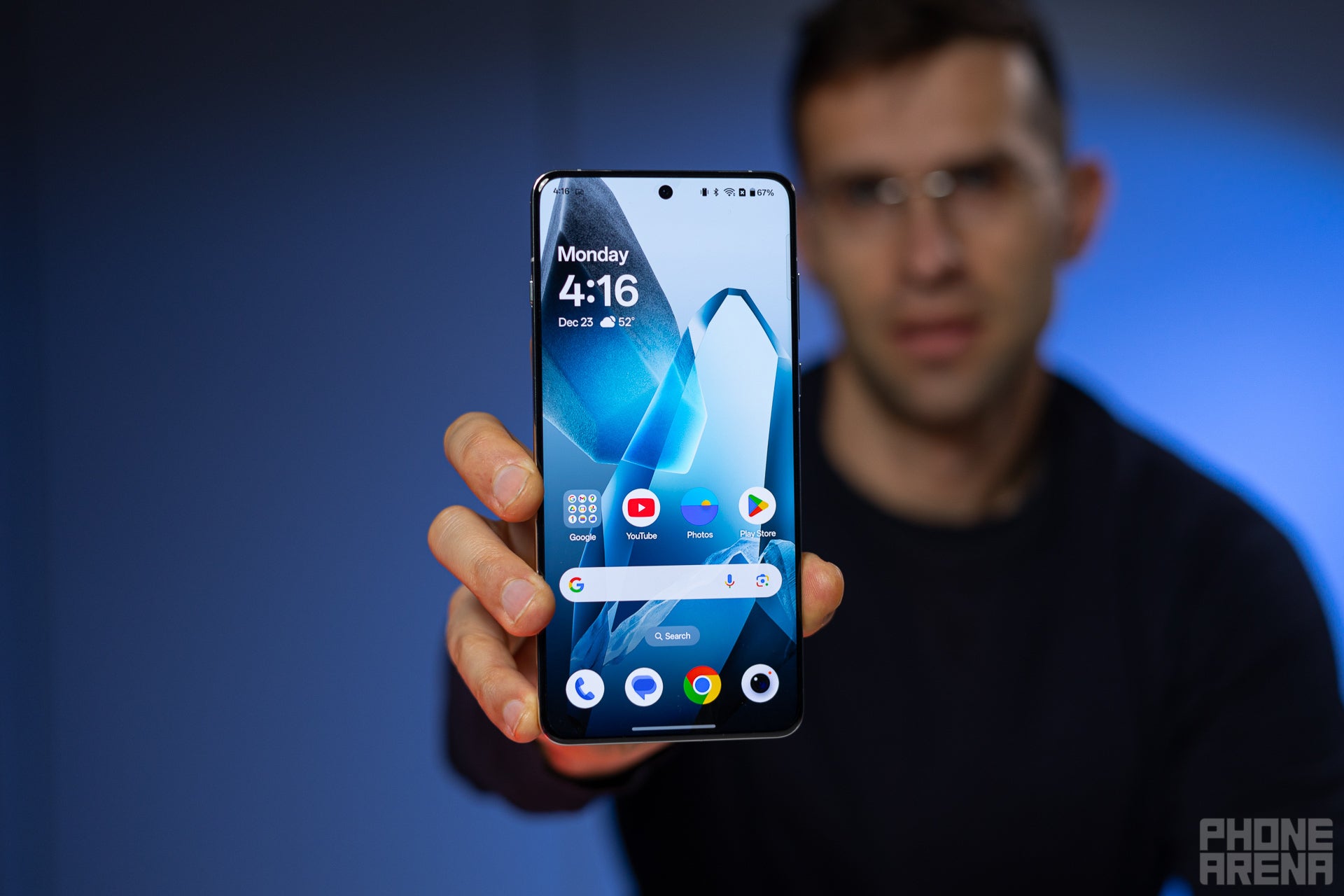 A man showing the display of the OnePlus 13.