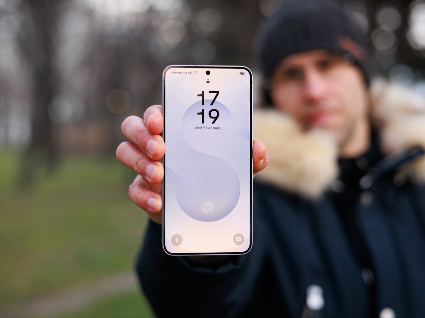 Holding up a Samsung Galaxy S25 outdoors