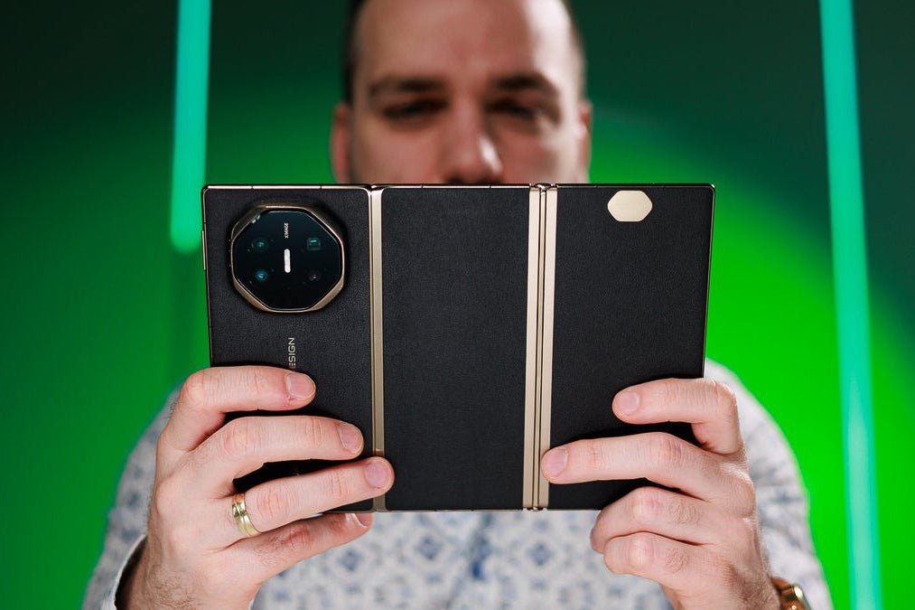 Foldable phone opened like a book, showing large inner display held with both hands.