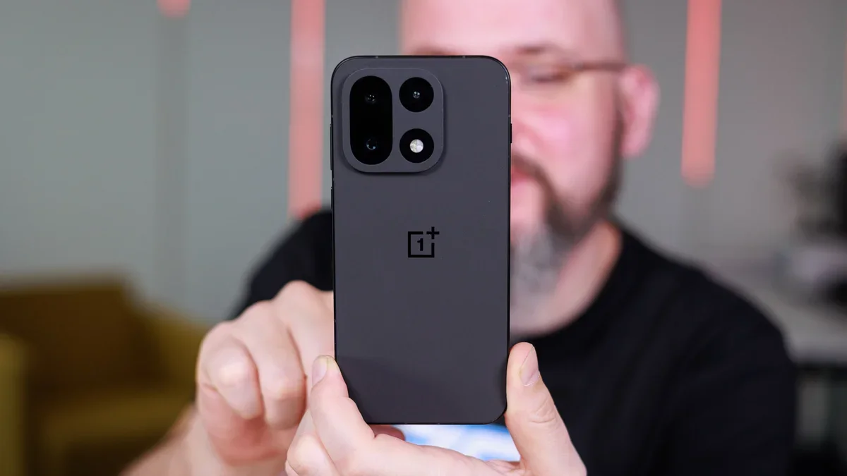 OnePlus phone held in hand by a man.