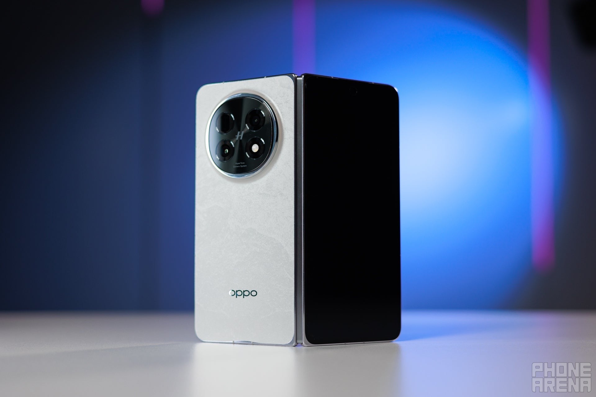 Oppo foldable phone standing half-open on a table, showing the rear camera module and hinge.