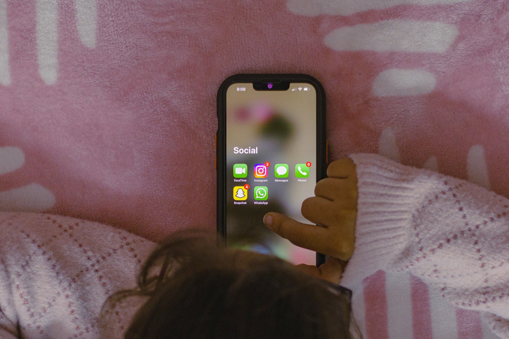 Child using a smartphone showing social media apps
