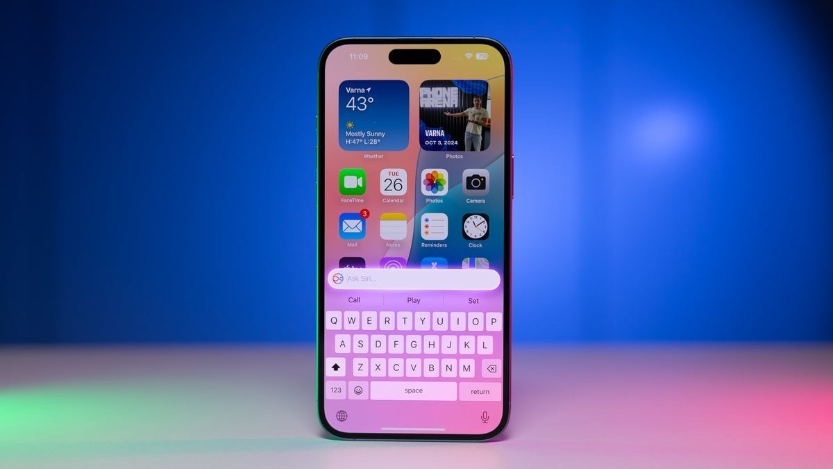 iPhone home screen with Siri search and keyboard active