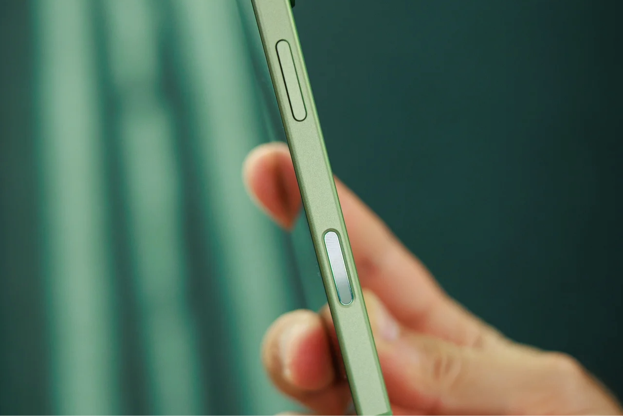 A hand holding the iPhone 17 showing its side with the Camera Control button on display. 