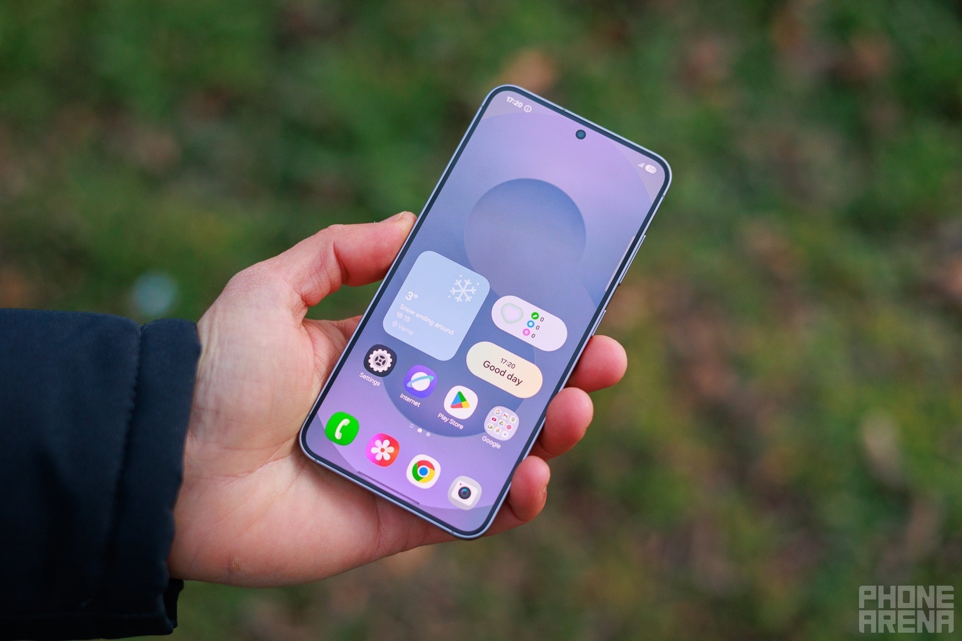 Samsung Galaxy S25 front display held in hand outdoors