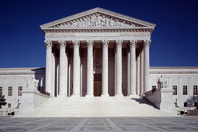 The front facade of the US Supreme Court building, with its marble columns and steps.