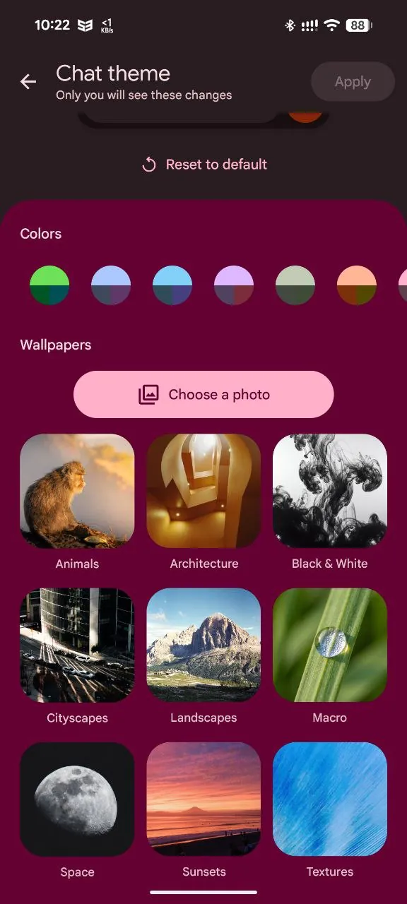 Google Messages Chat theme screen showing a row of color palette options and a wallpaper gallery sorted into categories like Animals, Cityscapes, Landscapes, Space, Sunsets and Textures, plus a Choose a photo button and a Reset to default option.