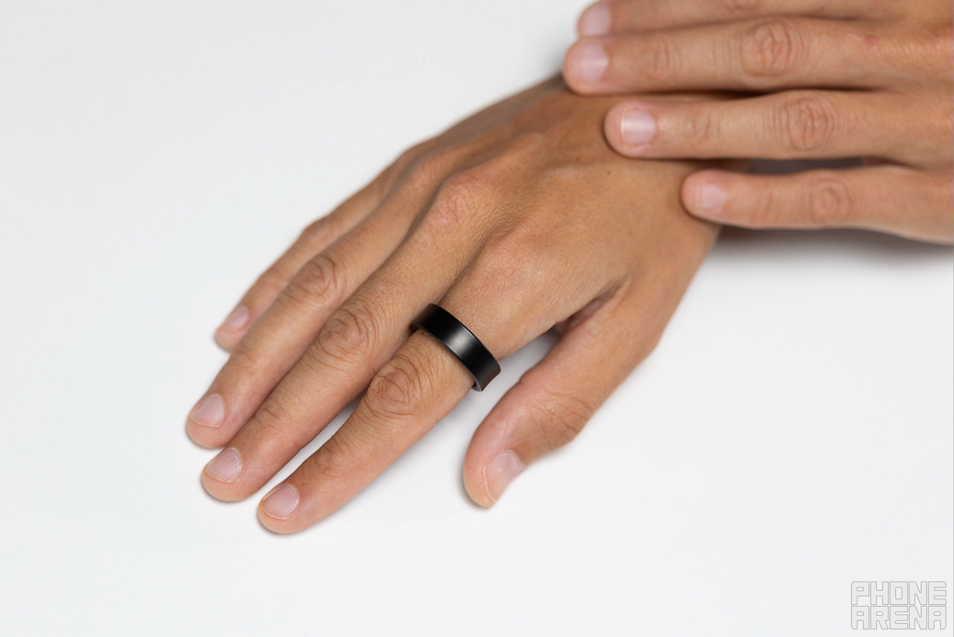 Samsung Galaxy Ring worn on a finger, showing the sleek black titanium band against a white background.