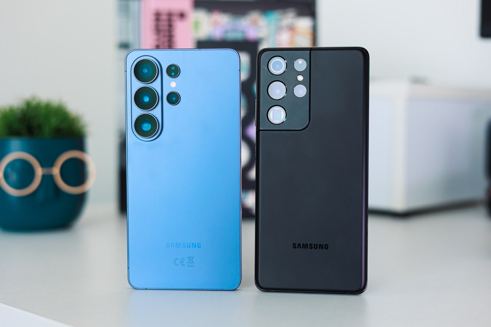 A blue and a black Galaxy S Ultra phones on a desk.