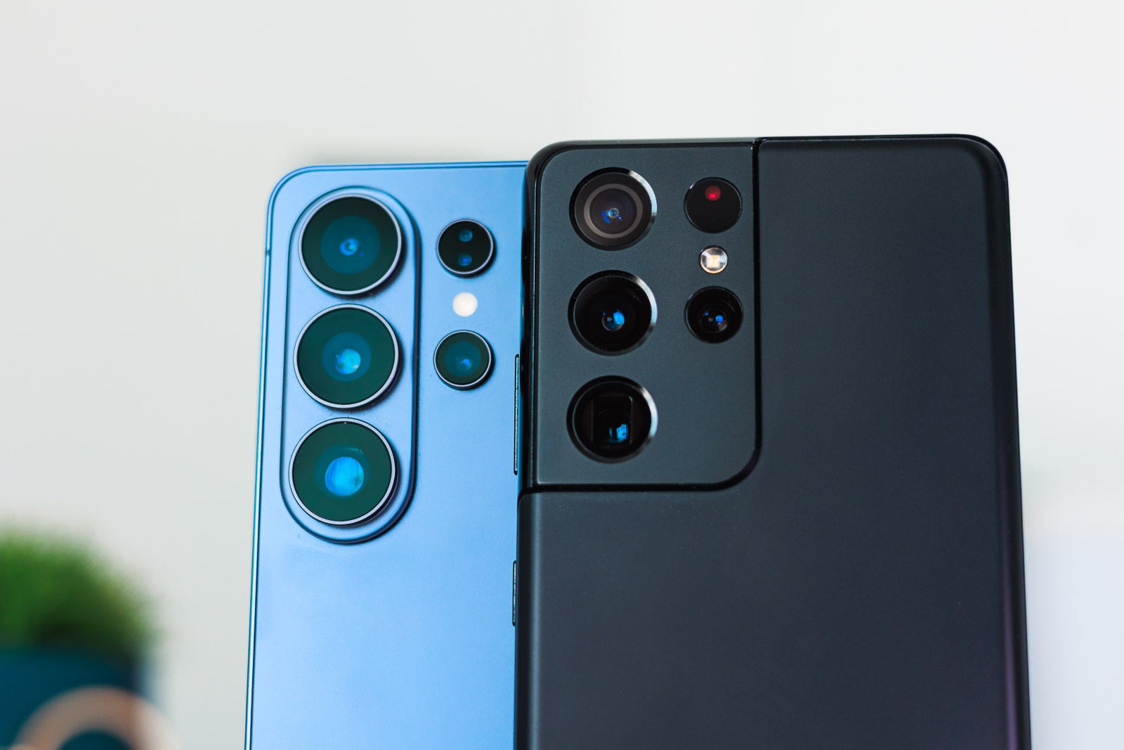 A blue and a black Galaxy S Ultra phones on a desk, closeup.