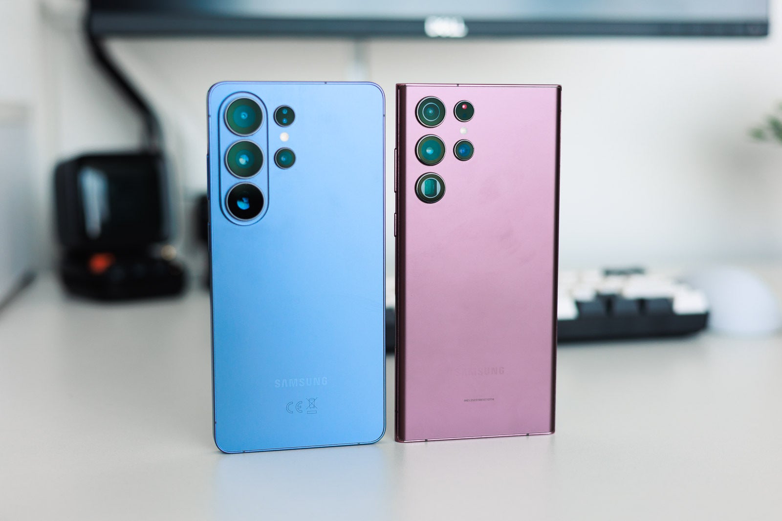 A blue and a pink Galaxy S Ultra phones on a desk.
