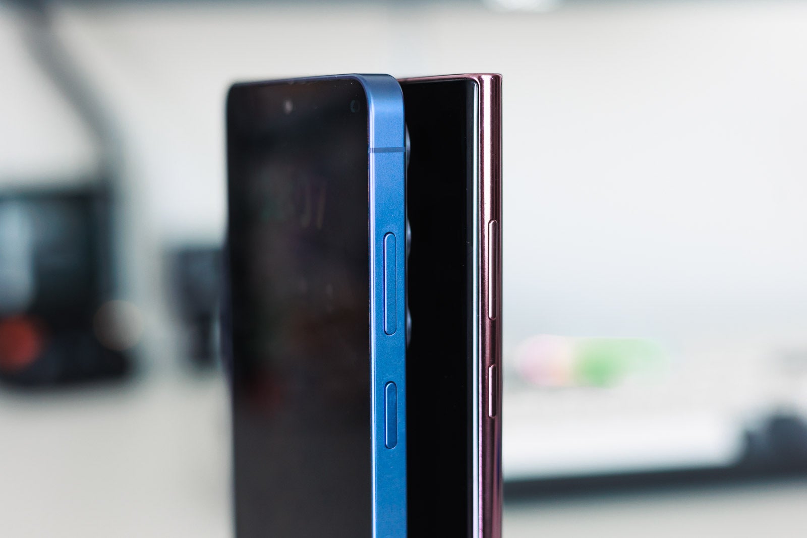 A blue and a pink Galaxy S Ultra phones on a desk, sideways.