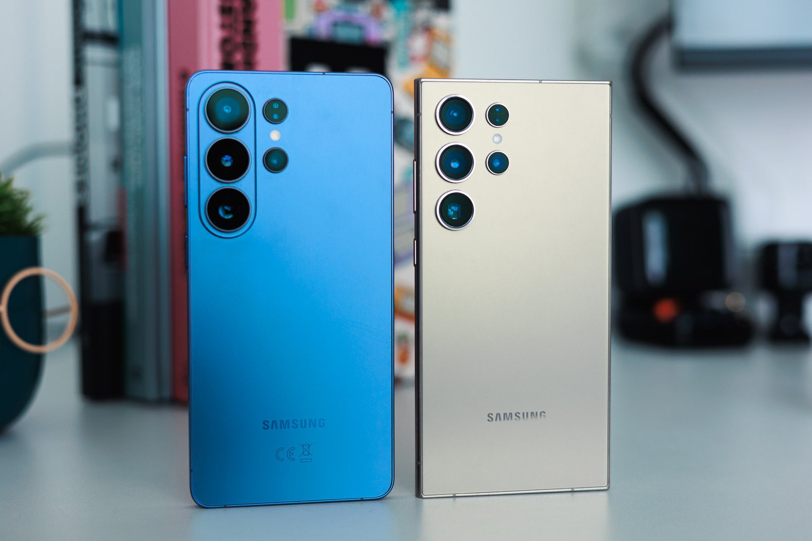A blue and a golden Galaxy S Ultra phones on a desk.