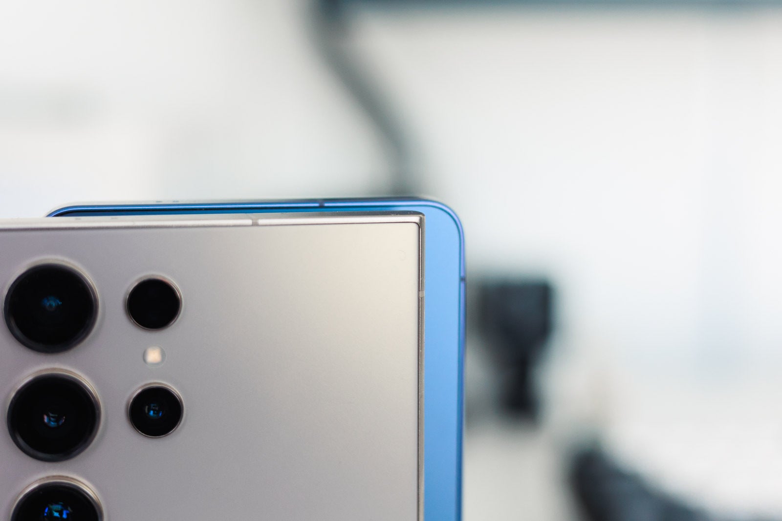 A blue and a golden Galaxy S Ultra phones on a desk, closeup.