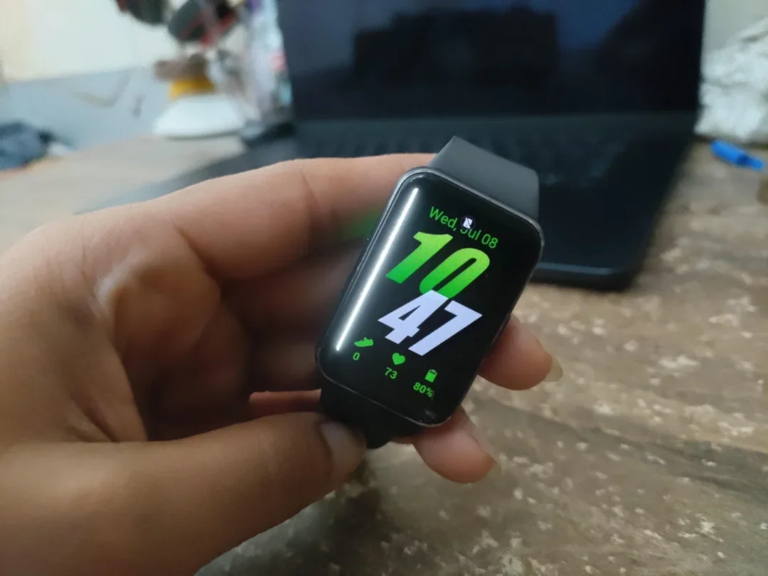 Person holding Galaxy Fit 3 with green line across display