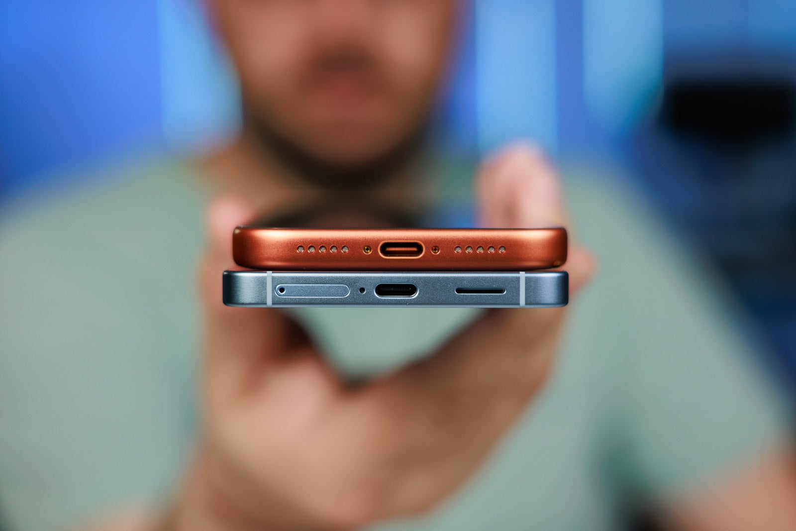 A man holding two flagship phones by Samsung and Apple.