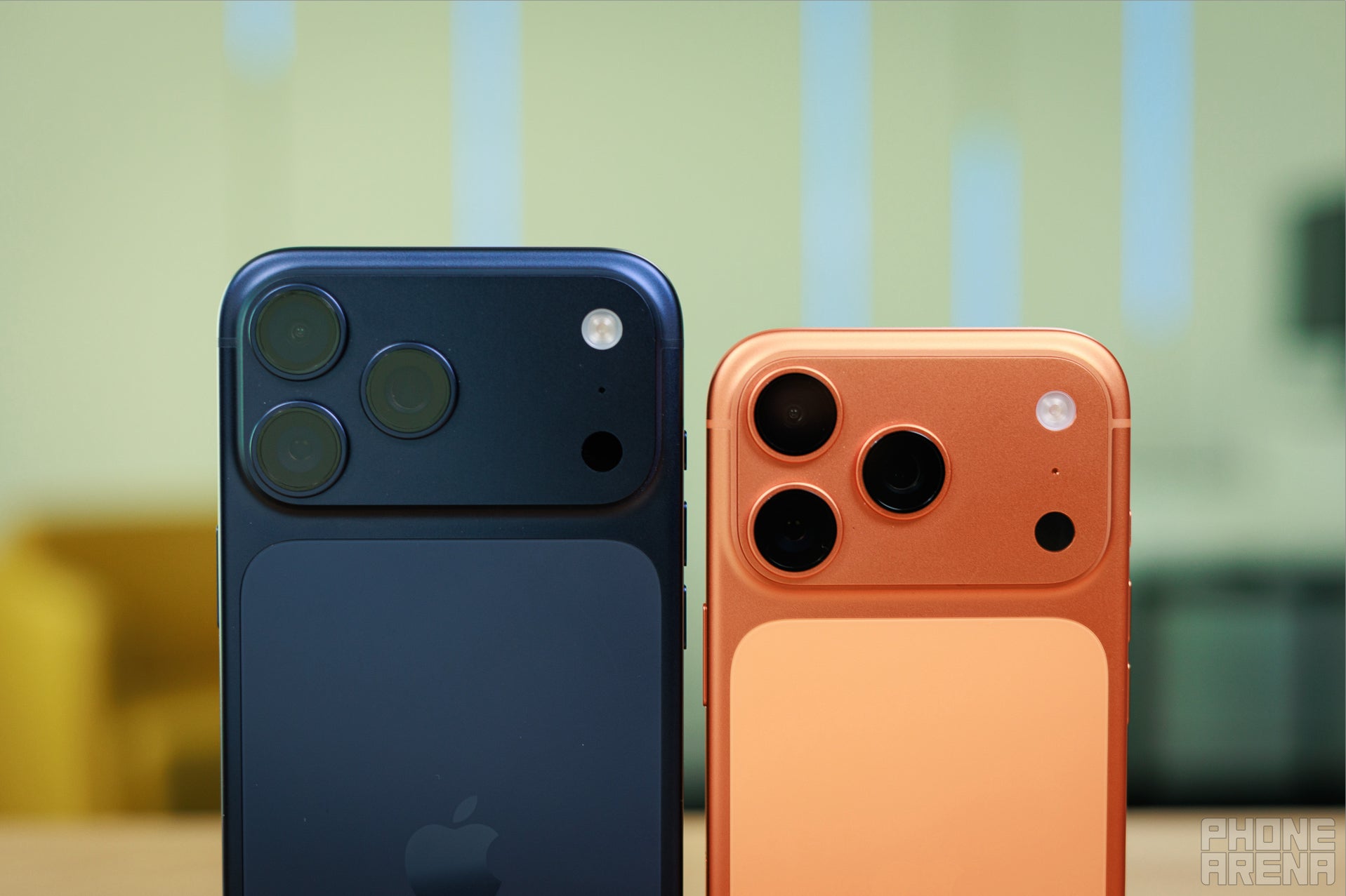 iPhone 17 Pro Max in dark blue beside iPhone 17 Pro in orange