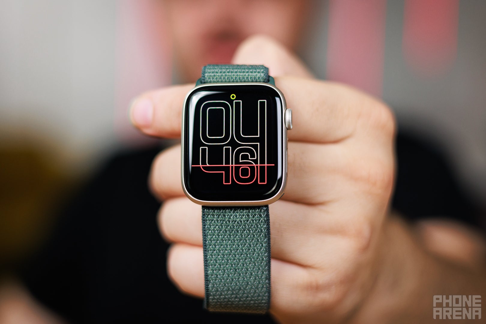 Apple Watch SE 3 held up showing a digital clock face