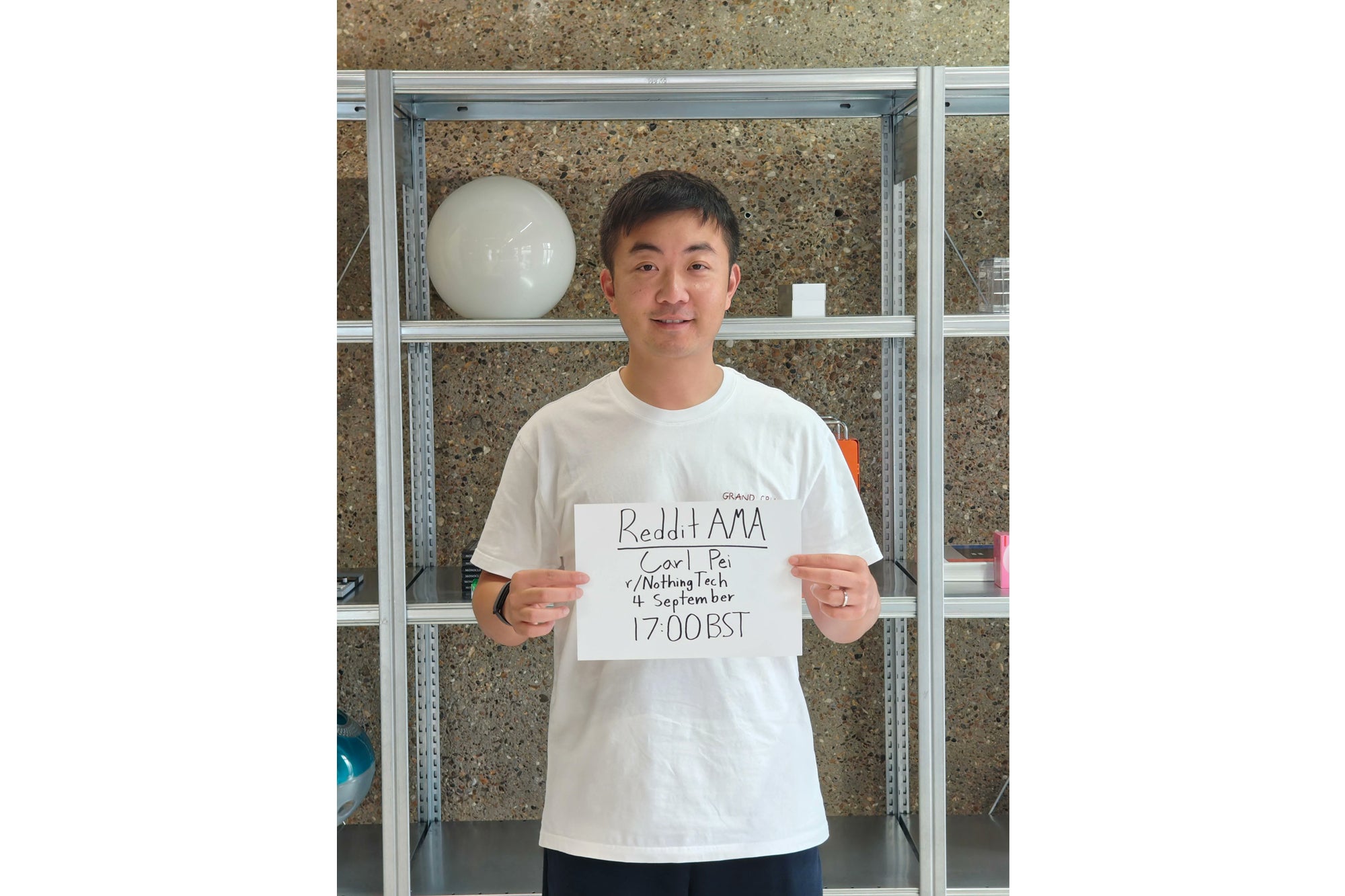 Carl Pei holding a handwritten sign announcing his Reddit AMA