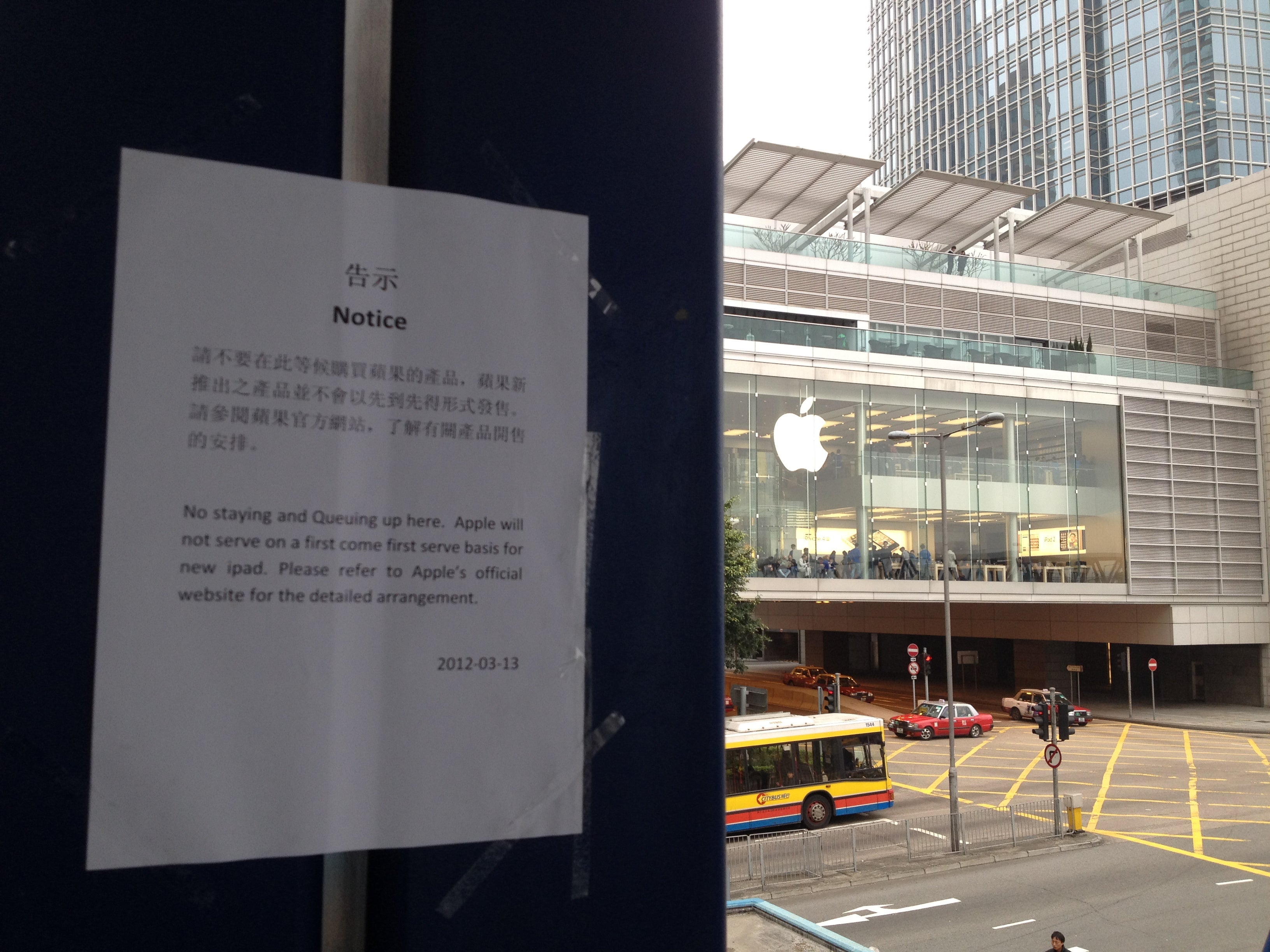 While posts say no lines are allowed at the Hong Kong Apple Store (L), the crowd has moved to a footbridge hundreds of yards away (R) - Signs posted around Hong Kong Apple Store say new iPad won&#039;t be sold on first-come first-served basis