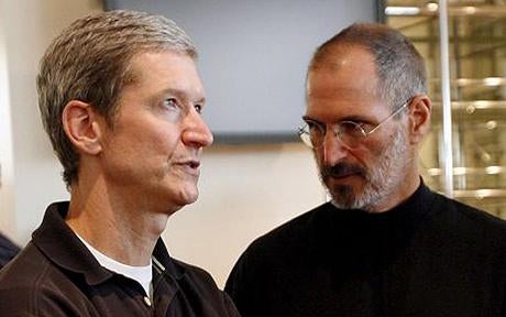 Apple CEO Tim Cook and his predecessor Steve Jobs at right - Samsung and Apple file to drop claims to get trial started on time