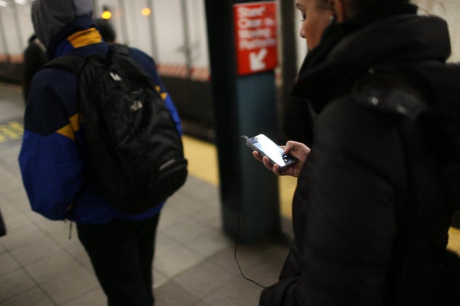 A New Yorker checks her Apple iPhone on a subway platform - One Apple iPhone 4S gets stolen twice in the same day