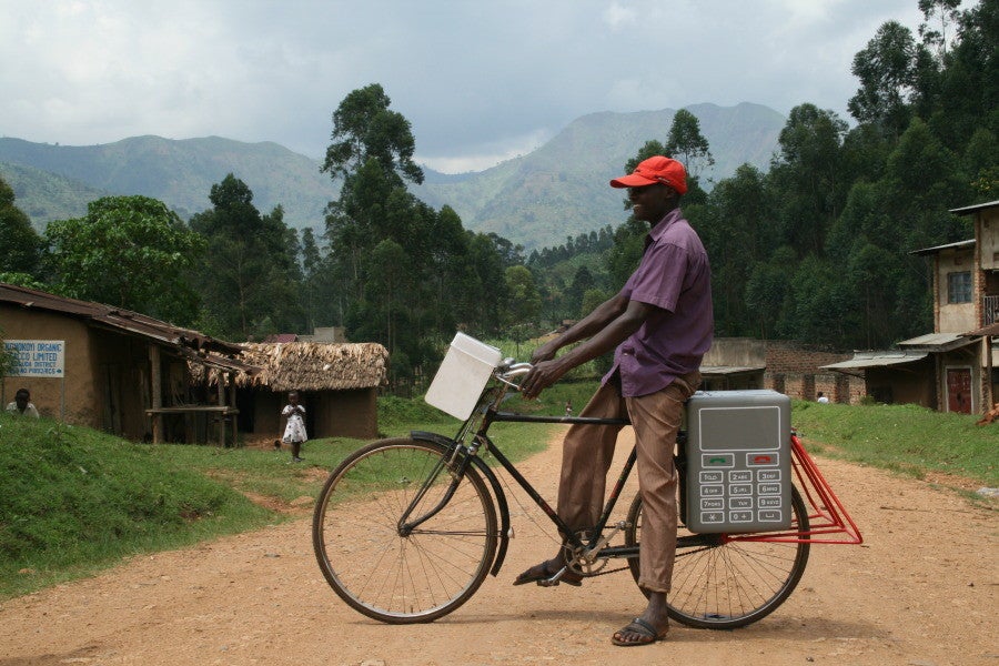 A Buffalo Grid battery being carried by bicycle in Uganda - Buffalo Grid recharges off-grid phones using solar power, bikes and text messages