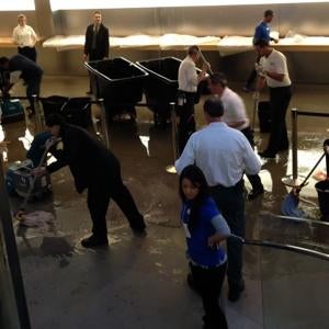 Workers mop up at the Fifth Avenue Apple Store following a flood - Big Apple rain showers flood the Fifth Avenue Apple Store