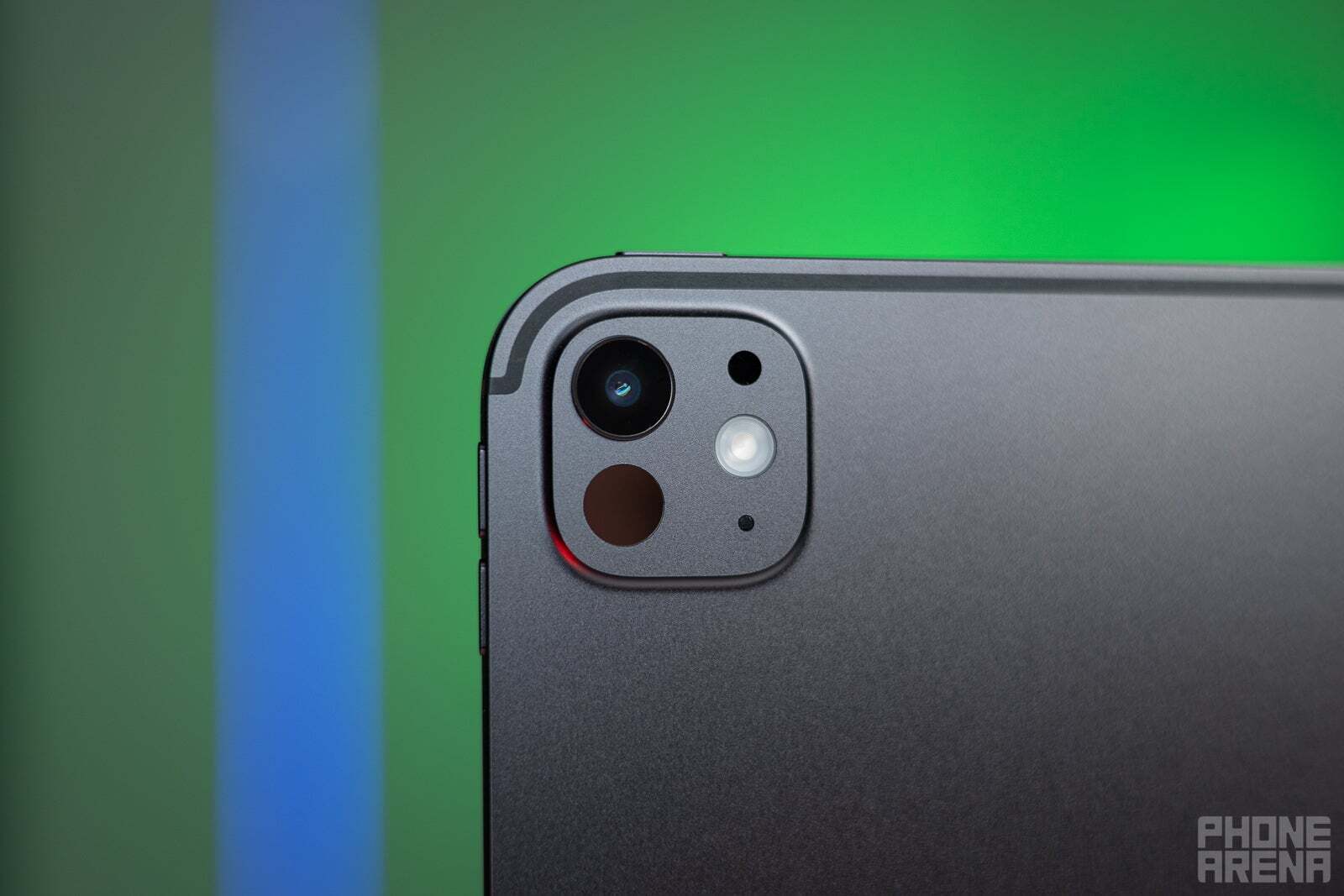 A close-up of the rear camera module of a gray iPad Pro.