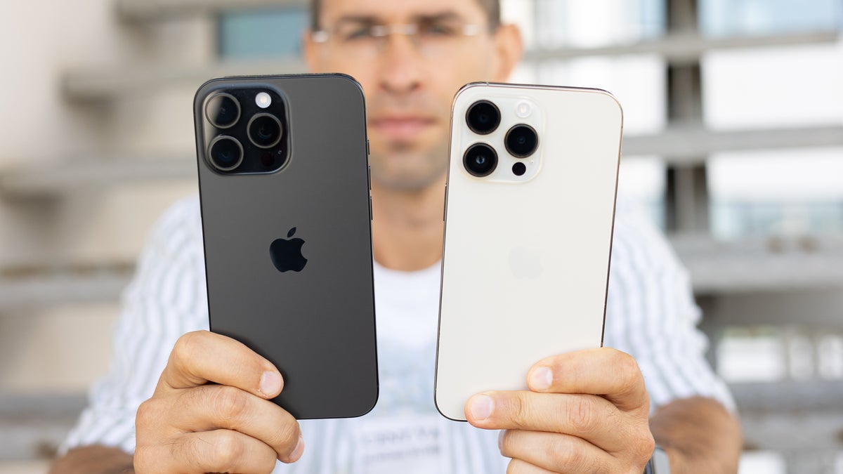 A man holding the Apple iPhone 16 Pro Max next to the iPhone 14 Pro Max