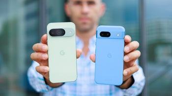 Man holding the Pixel 9 and 8a, backs facing the camera.