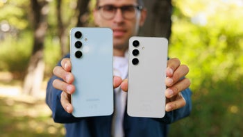 A hand holding two phones spread as a fan.