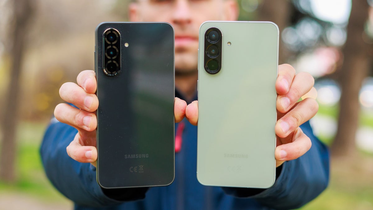 Man holding two phones with their backs facing the camera.