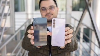 Person holding Galaxy A55 and A35; backs facing camera.