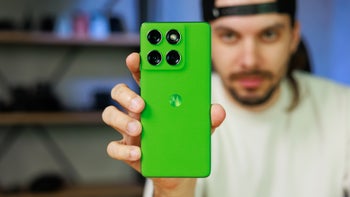 Man holding bright green phone in the middle of the frame.