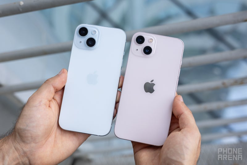 iPhone 15 next to iPhone 13 side by side in hands