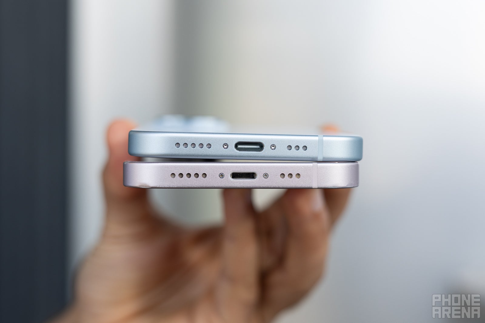 Person showing iPhone 15 and iPhone 13 USB C ports