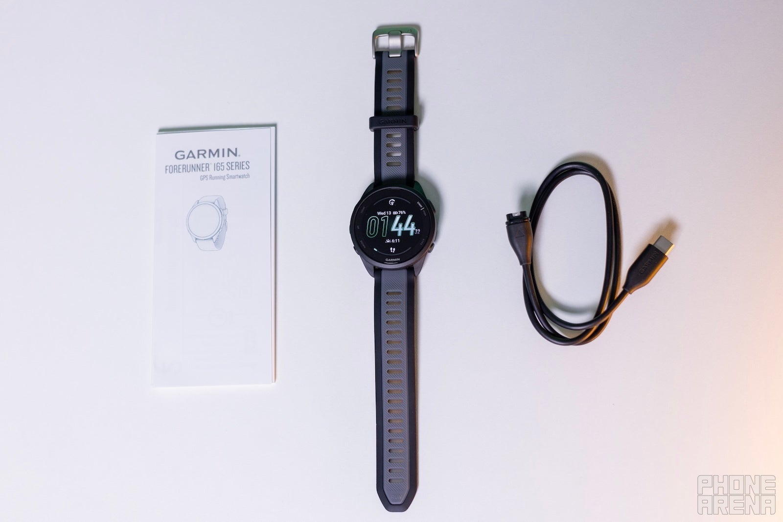 You will only find the watch, a charging cable and a user manual inside the box (Image by PhoneArena) - Garmin Forerunner 165 Review: The new default Garmin sports watch