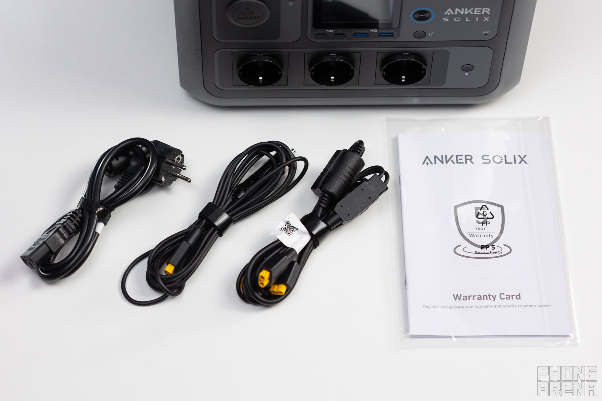 12V DC, Solar input, and wall charging cables, alongside a user manual for the Anker Solix C800 Plus, placed on a table.