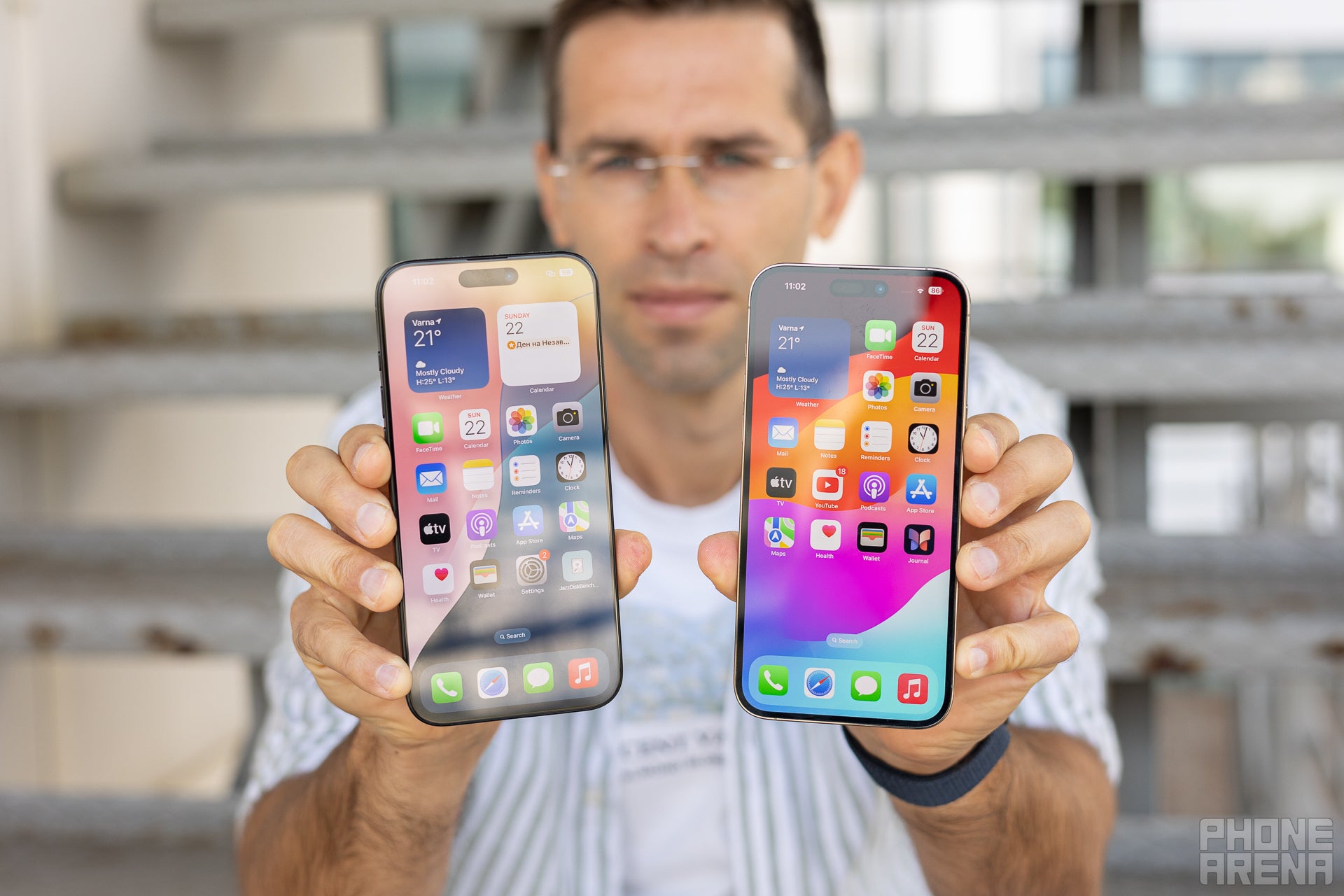 A man holding the Apple iPhone 16 Pro Max next to the iPhone 14 Pro Max