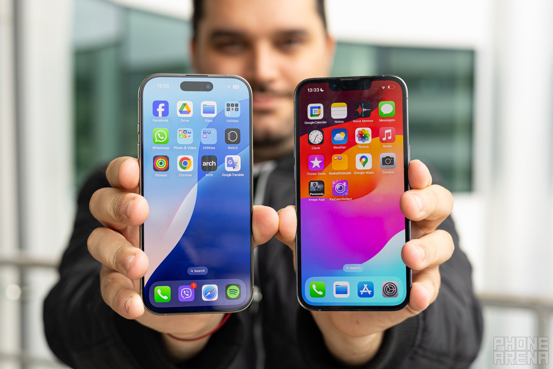 A man holding Apple iPhone 16 Pro next to the iPhone 13 Pro