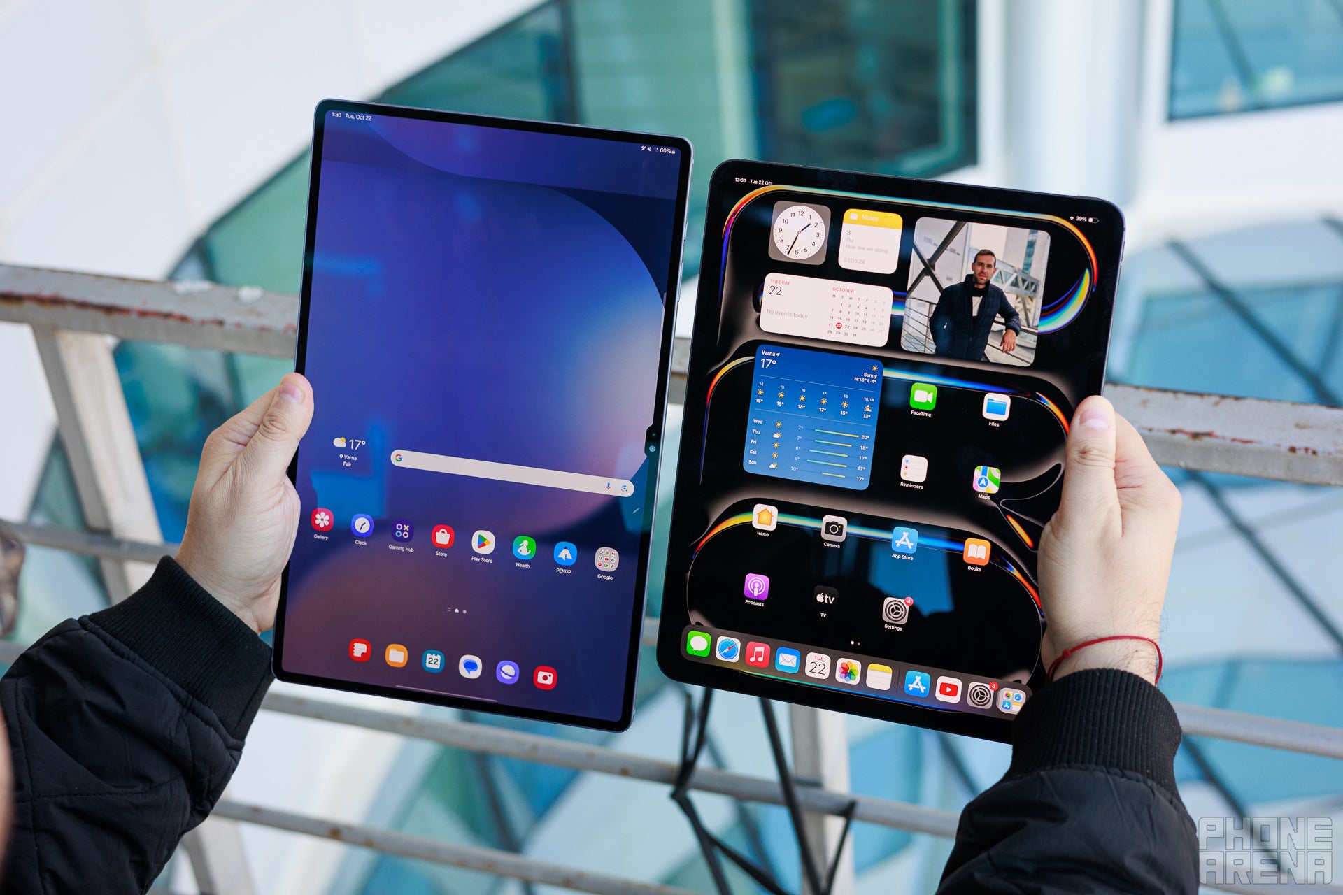 Galaxy Tab S10 Ultra and iPad Pro M4 13&amp;quot; held in two hands, the screens are showing the homescreens