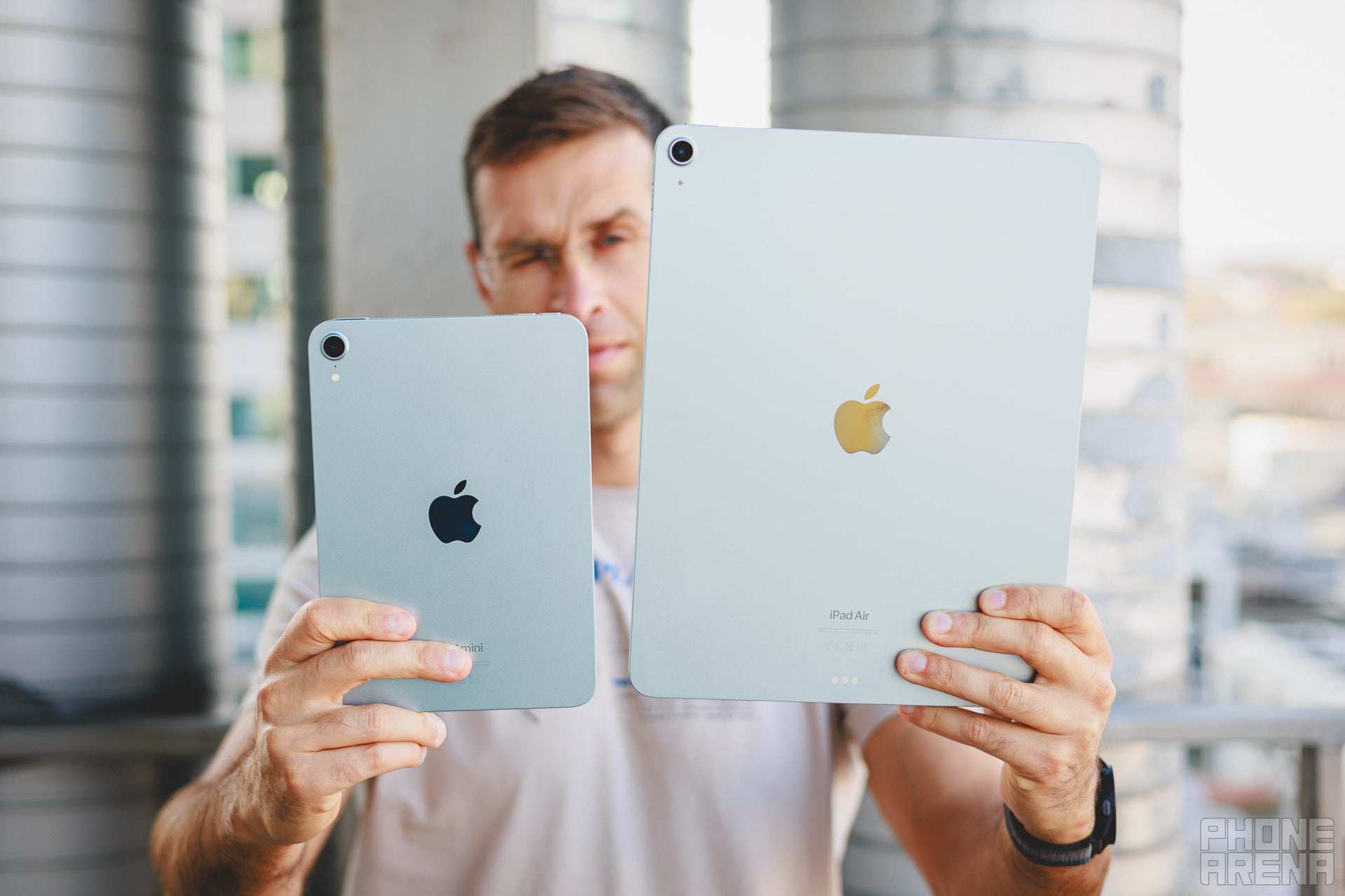 Person holding iPad mini and the iPad Air 13&amp;quot;, backs towards the camera