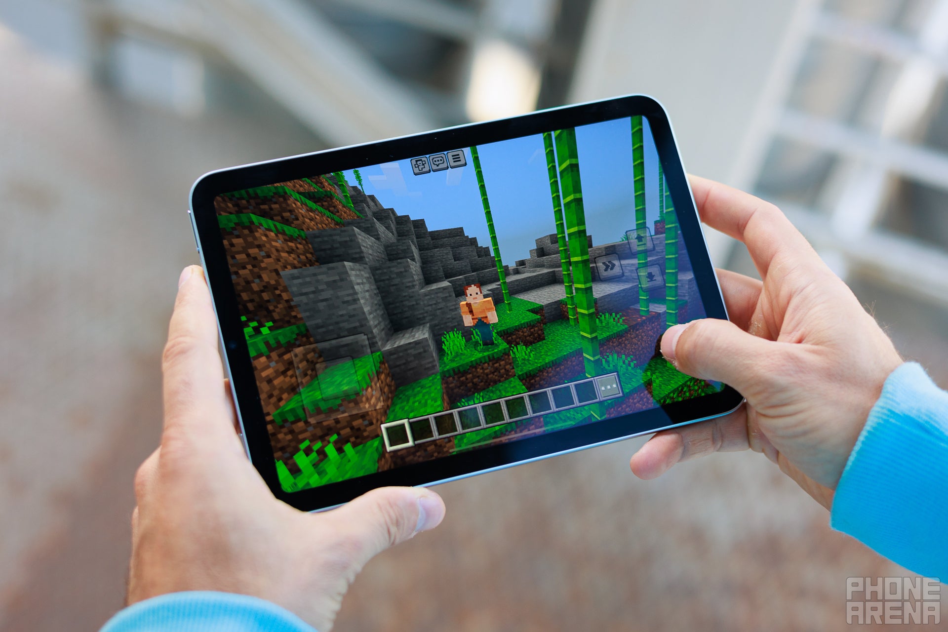 Person holding iPad mini, playing Minecraft on screen