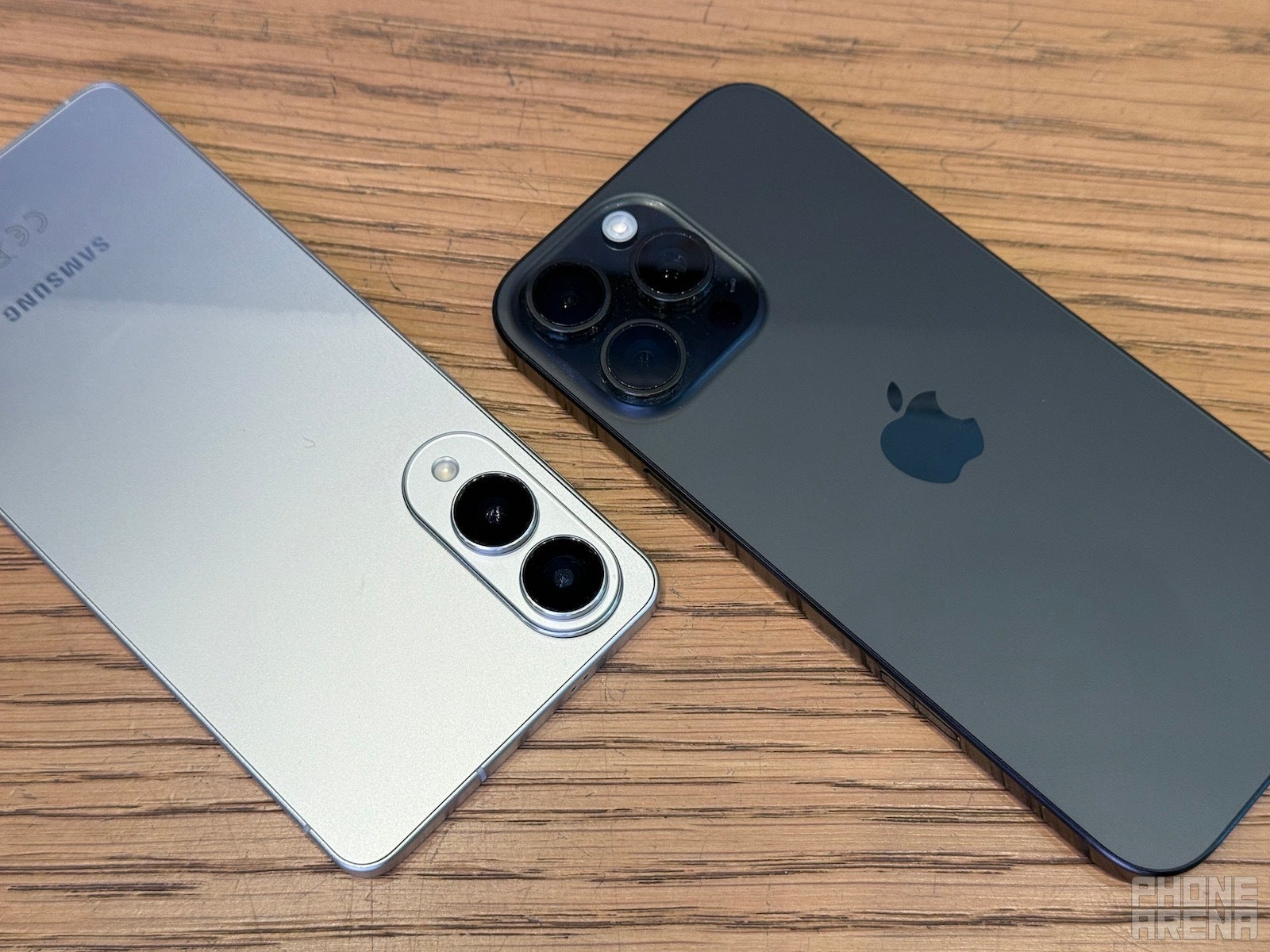 Galaxy S25 Edge and iPhone 16 Pro Max lying on table, backs towards the camera